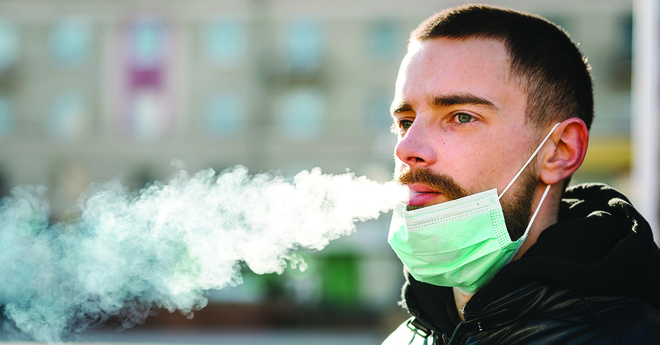 Guy Vaping or Smoking with Mask