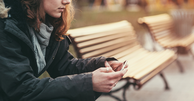 Woman sitting on a bench on her cellphone 