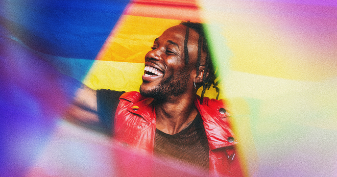 Black man holding up a pride flag
