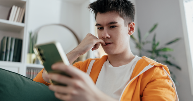 Young man watching content on his phone