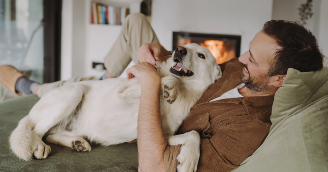 A man laying on the couch with his dog